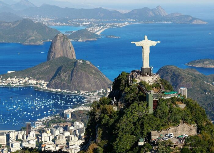 View of Christ the Redeemer overlooking Rio de Janeiro with Sugarloaf Mountain in the background, showcasing Brazil’s iconic landscape.