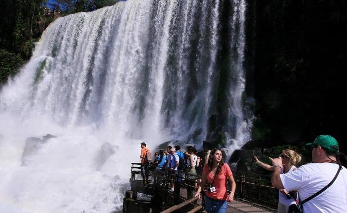 Panoramic view of Iguassu Falls cascading between lush rainforest on the Brazil and Argentina border, with mist rising from Devil’s Throat